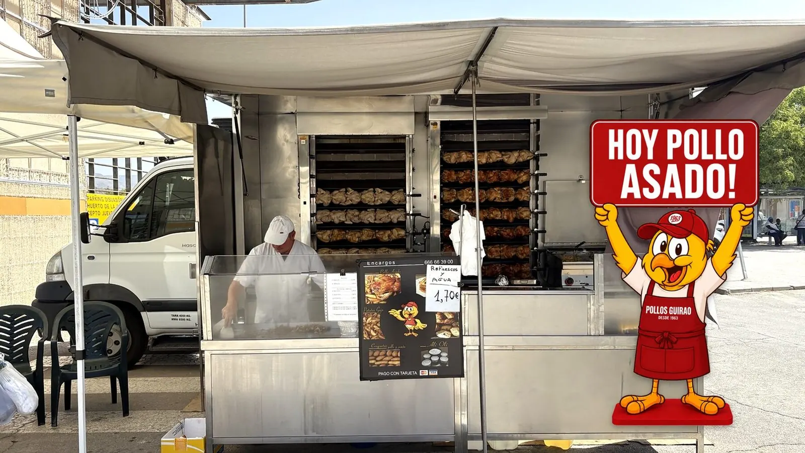 Camión de Pollos Guirao asando pollos en el mercado, con la mascota anunciando que hoy hay pollo asado